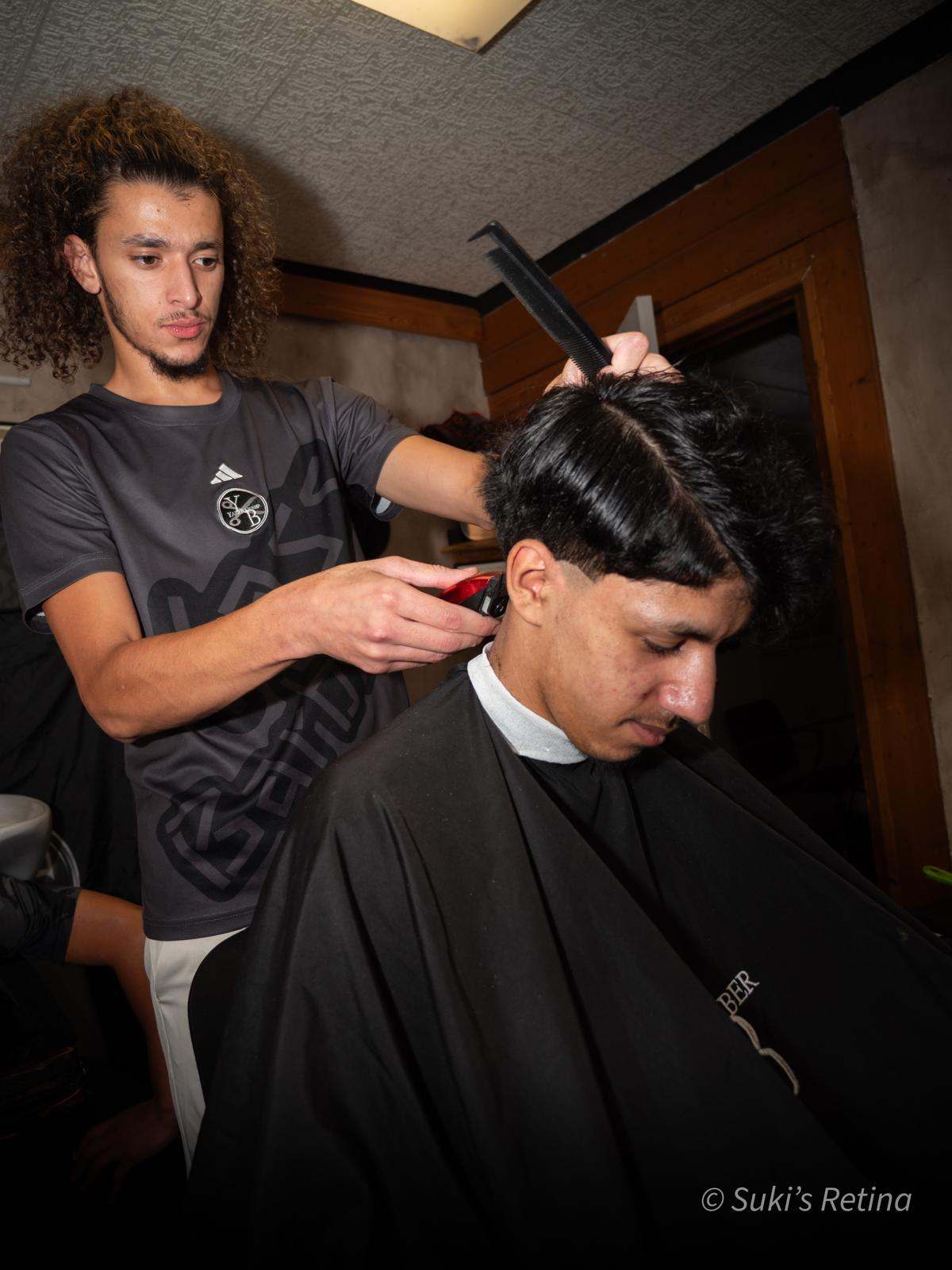 Yass au travail dans son barbershop de Briançon, dégradé à la tondeuse